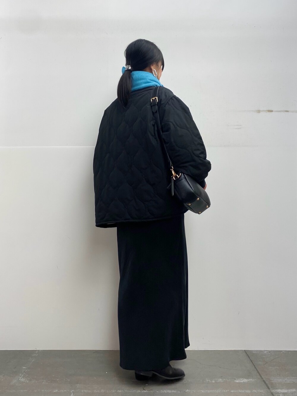 ブラック系のブルゾン、ホワイト系のTシャツ/カットソー、ブラック系のスカートを着用したレディースの秋コーディネートの3枚目の写真