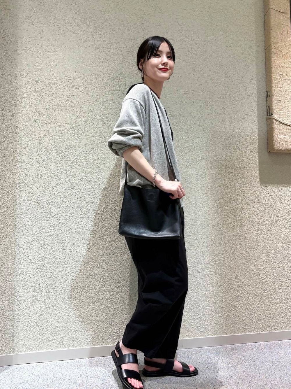 ブラック系のその他パンツ、グレー系のニット/セーターを着用したレディースの春コーディネートの2枚目の写真