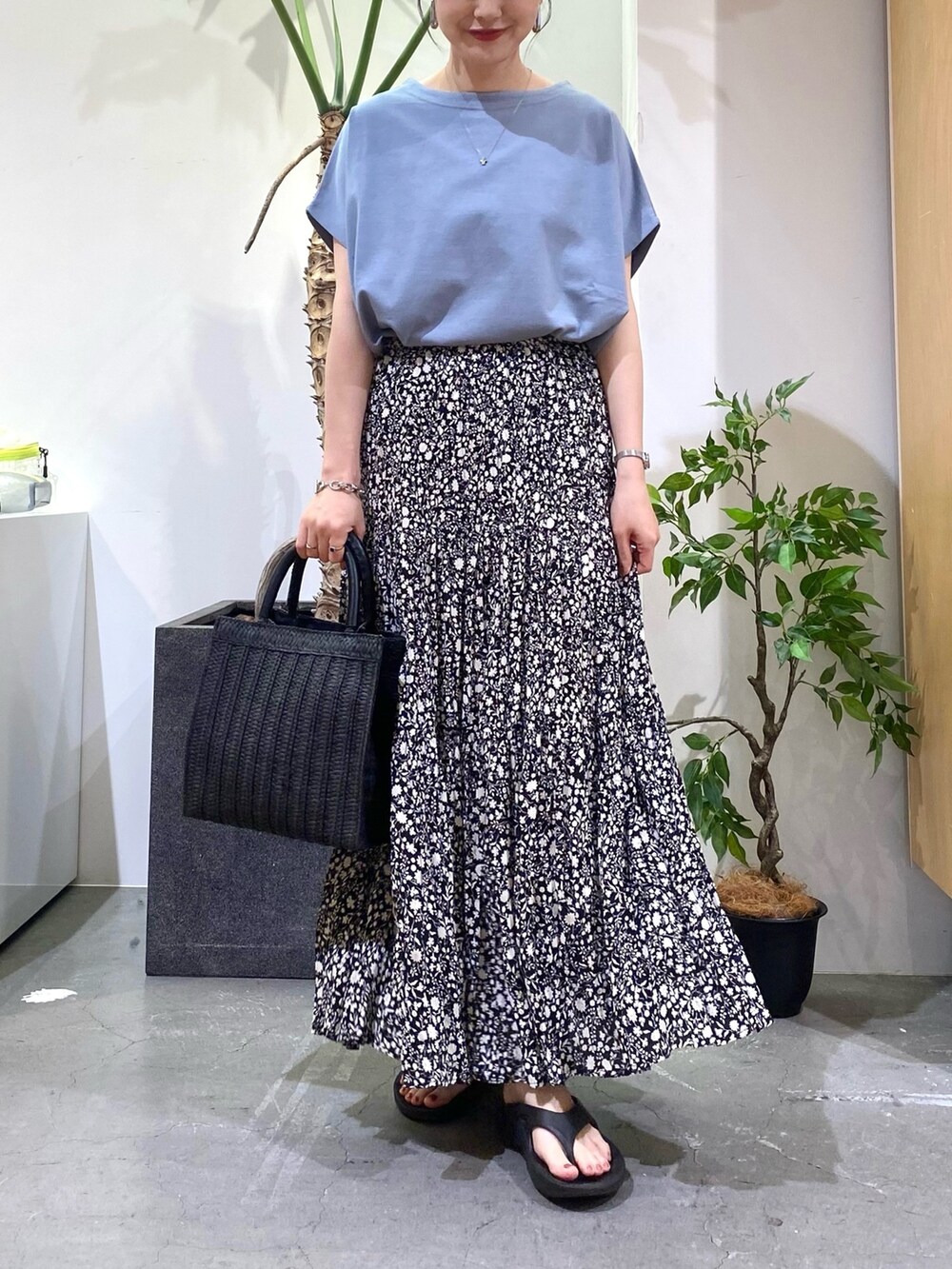 ブルー系のTシャツ/カットソー、ブラック系のスカート、ブラック系のハンドバッグを着用したレディースの春コーディネートの4枚目の写真