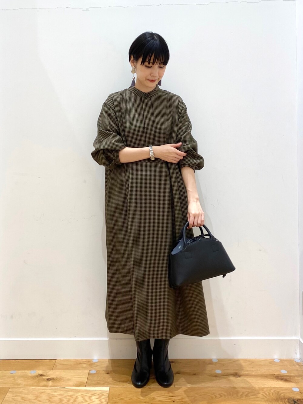 ブラウン系のステンカラーコート、その他のワンピース、ブラック系のショルダーバッグを着用したレディースの秋コーディネートの4枚目の写真