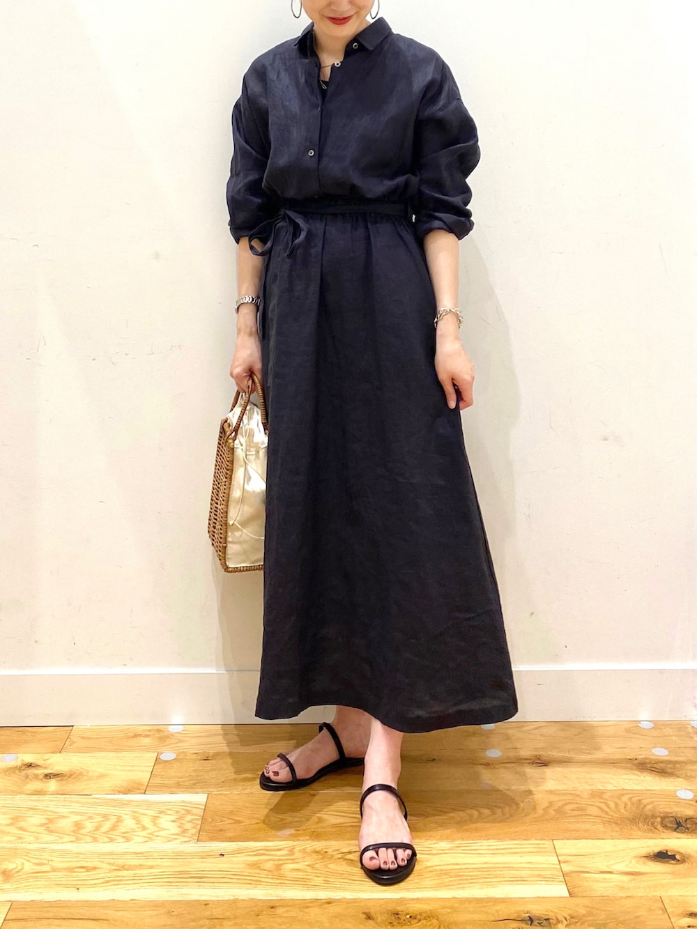 ブルー系のワンピース、ホワイト系のハンドバッグ、ブラック系のサンダルを着用したレディースの夏コーディネートの4枚目の写真