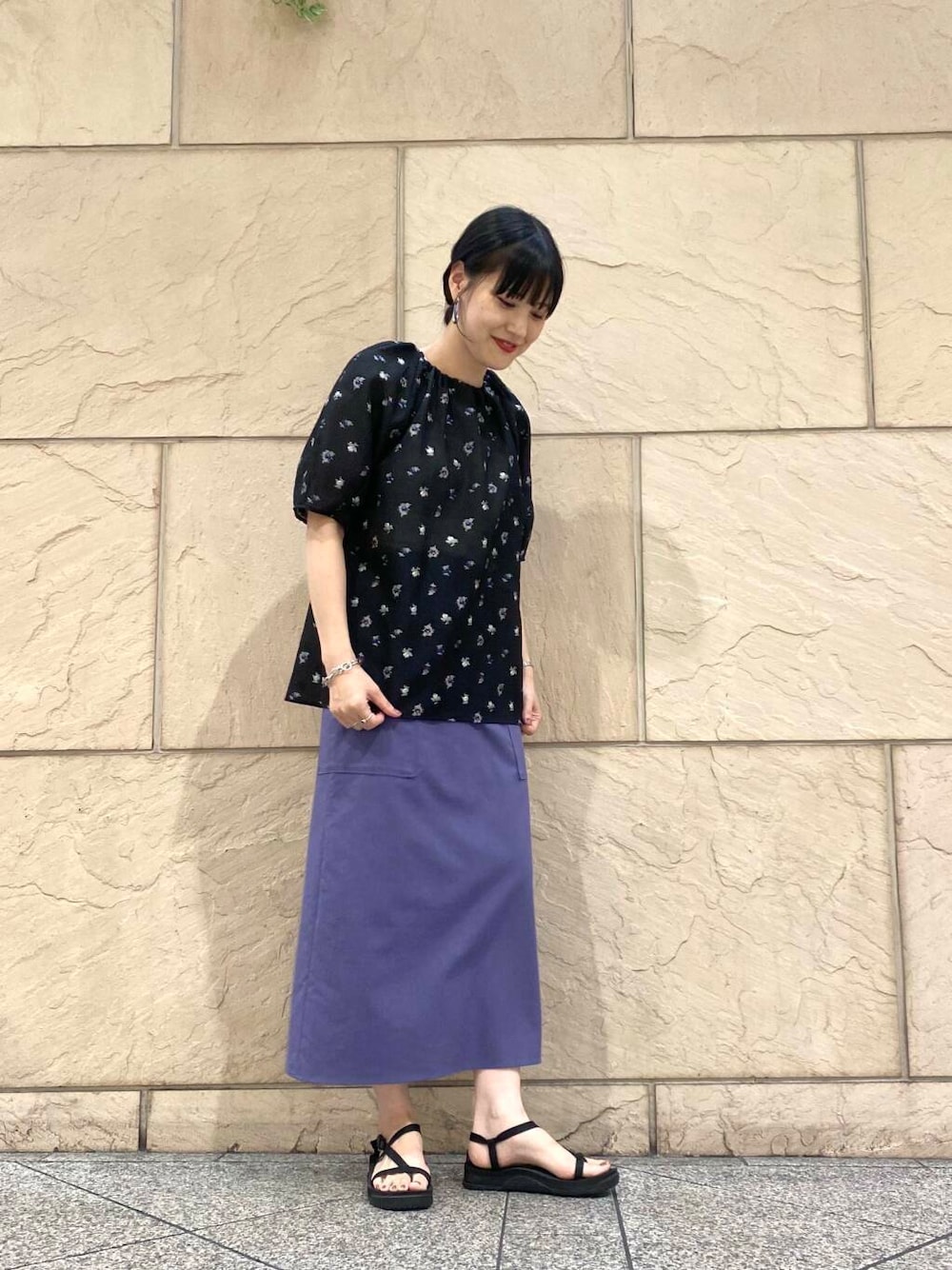 パープル系のスカート、ブラック系のシャツ/ブラウスを着用したレディースの夏コーディネートの2枚目の写真