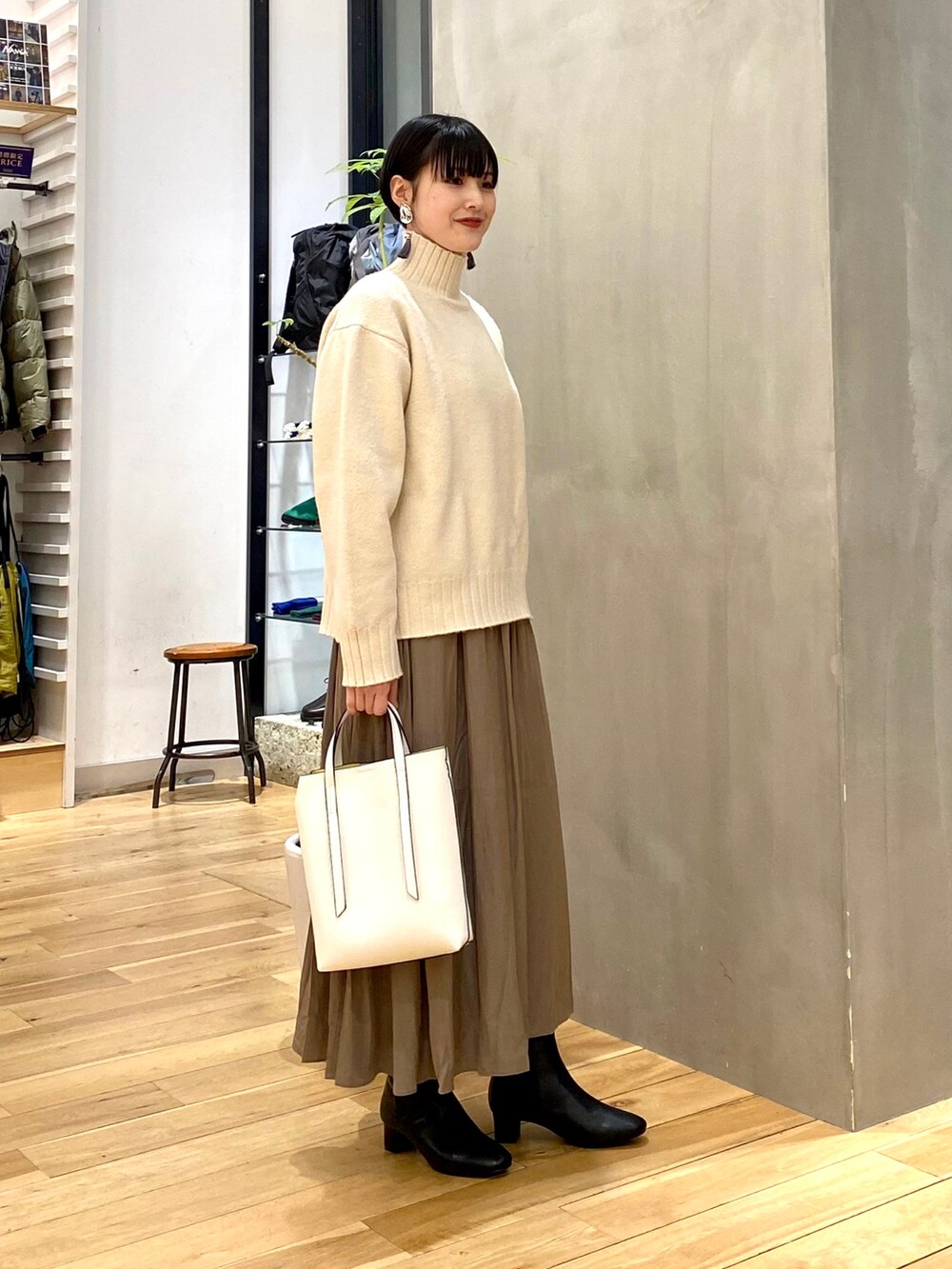 ベージュ系のダウンジャケット/コート、ホワイト系のニット/セーター、ブラウン系のスカートを着用したレディースの冬コーディネートの4枚目の写真