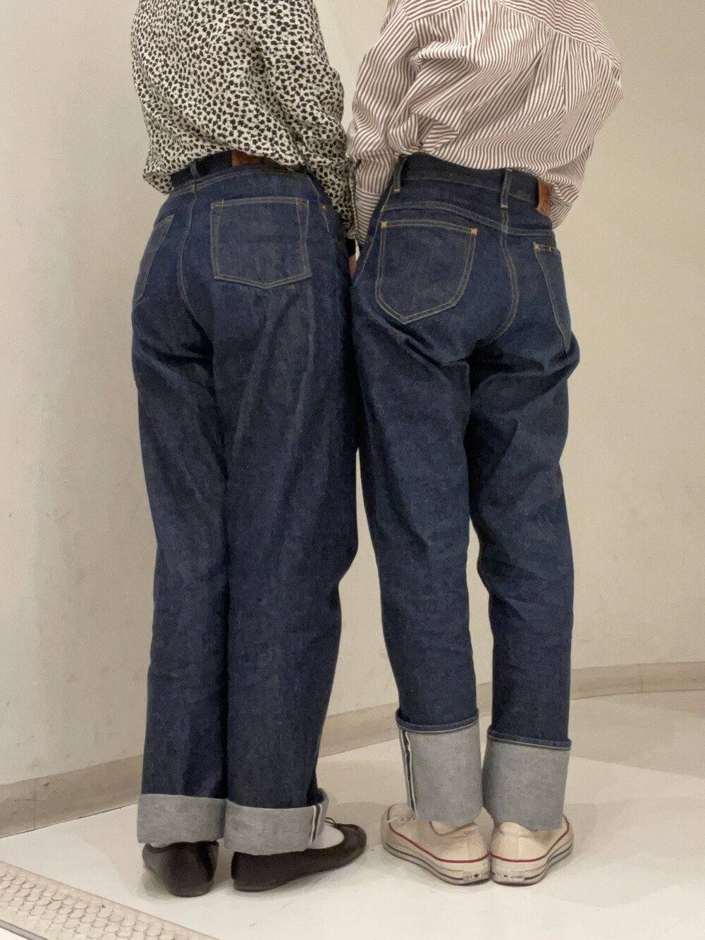 ブルー系のデニムパンツ、ブラック系のショルダーバッグ、ベージュ系のシャツ/ブラウスを着用したレディースの秋コーディネートの2枚目の写真