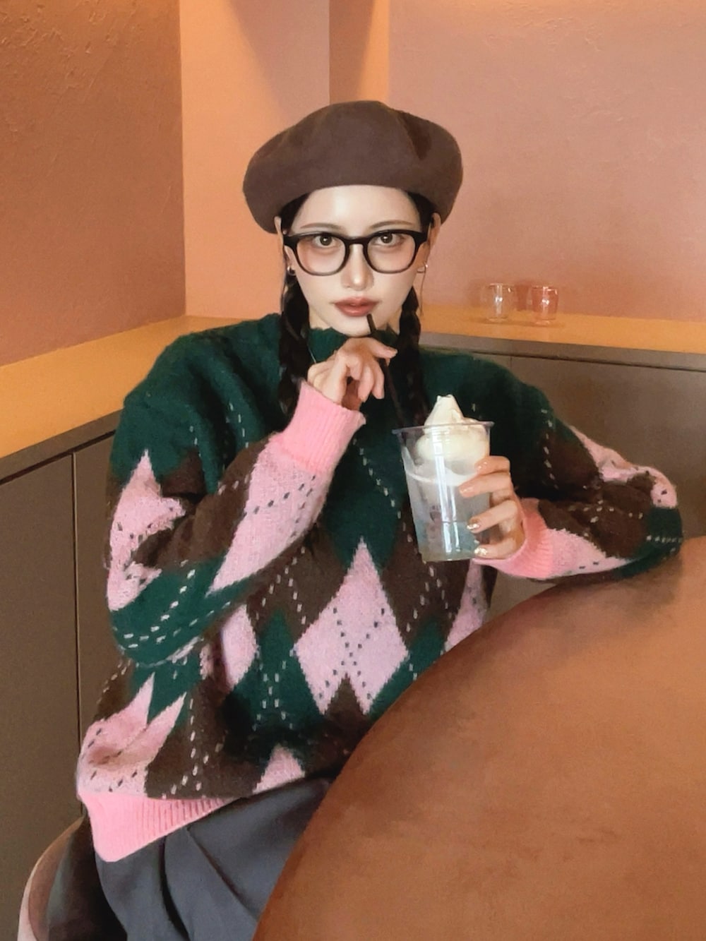 ピンク系のニット/セーター、ベージュ系のショルダーバッグ、ブラウン系のブーツを着用したレディースの秋コーディネートの3枚目の写真