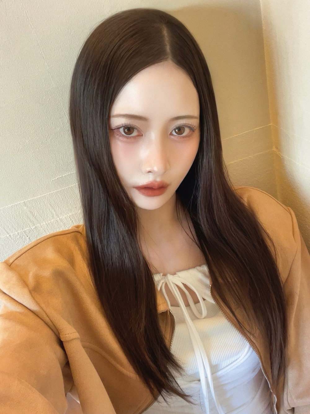 ベージュ系のジャケット/アウター、ホワイト系のトップス、ブルー系のデニムパンツを着用したレディースの秋コーディネートの4枚目の写真