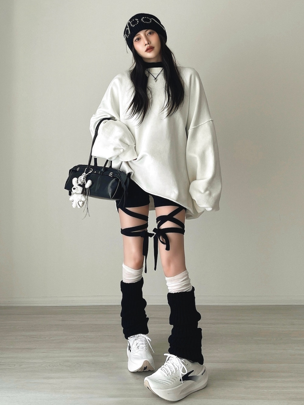 ブラック系のその他パンツ、ブラック系のショルダーバッグ、ホワイト系のシューズを着用したレディースの冬コーディネートの5枚目の写真