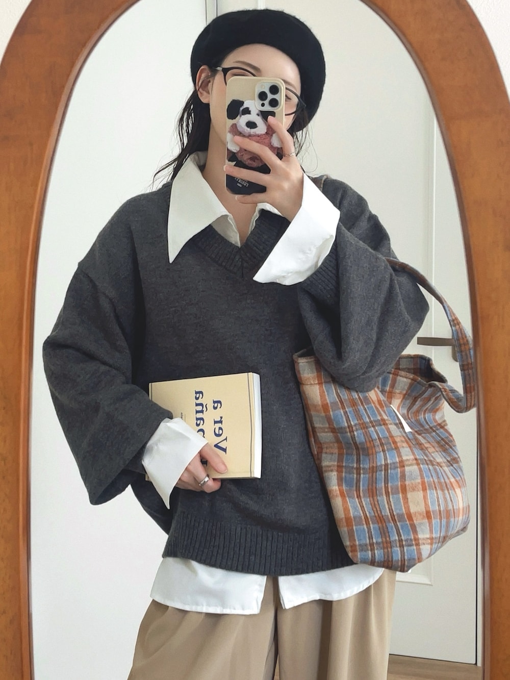 グレー系のニット/セーター、ホワイト系のシャツ/ブラウス、ベージュ系のパンツを着用したレディースの秋コーディネートの4枚目の写真