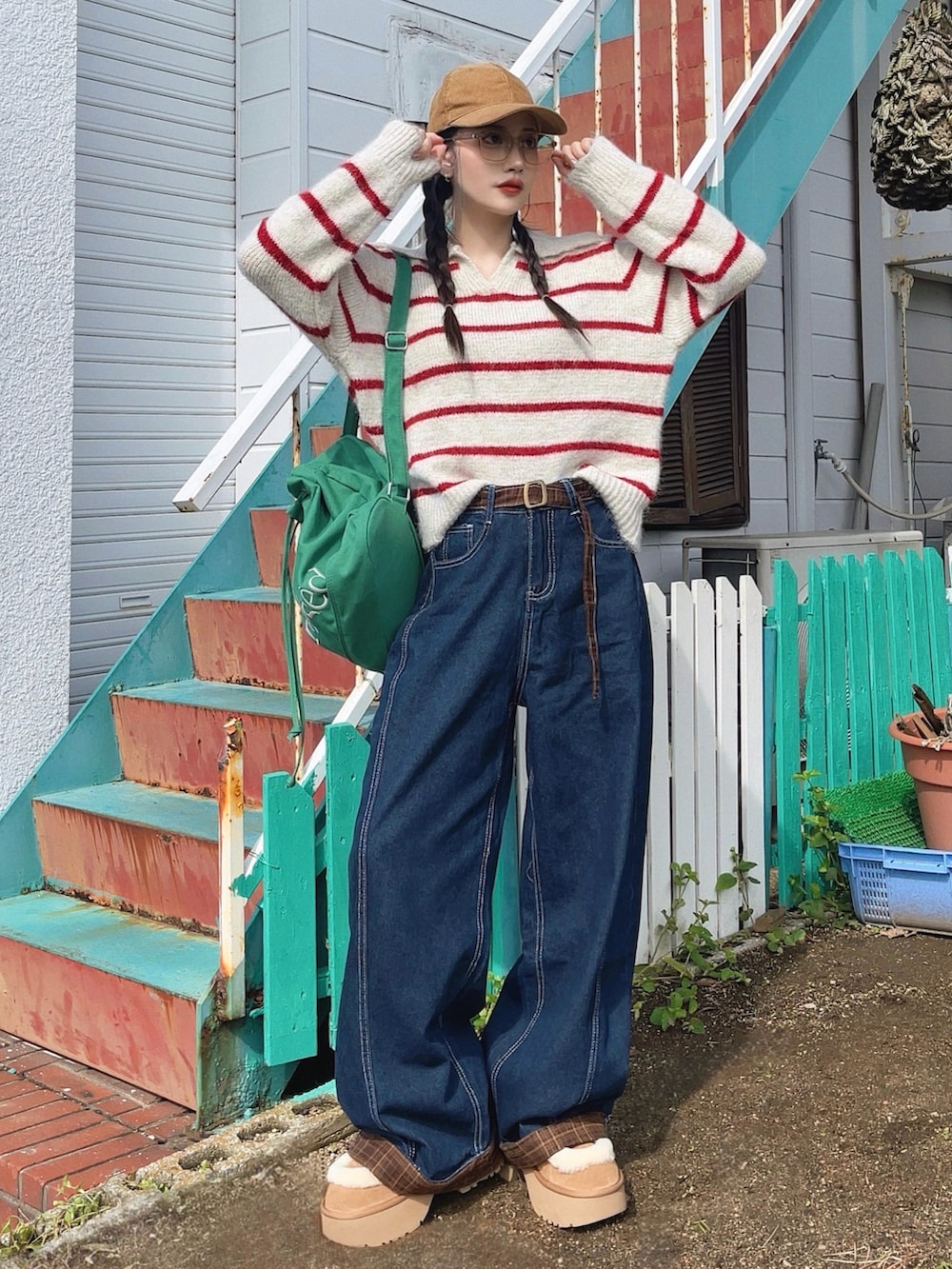 ブルー系のデニムパンツ、グリーン系のバックパック/リュック、ベージュ系のブーツを着用したレディースの秋コーディネートの4枚目の写真