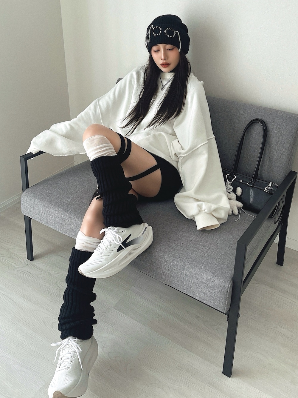 ブラック系のその他パンツ、ブラック系のショルダーバッグ、ホワイト系のシューズを着用したレディースの冬コーディネートの4枚目の写真