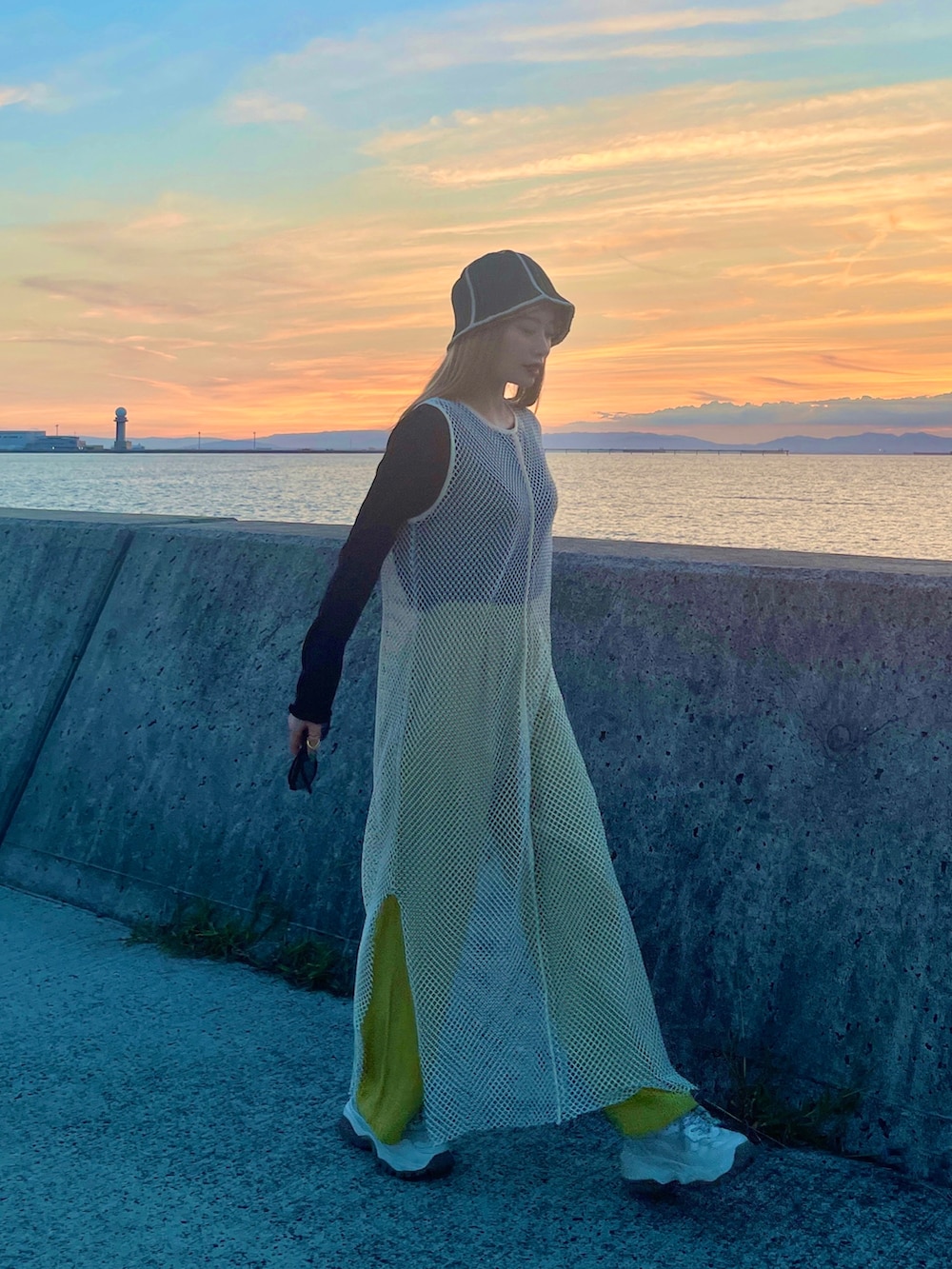 ホワイト系のワンピース、グリーン系のパンツ、ブラック系のトップスを着用したレディースの秋コーディネートの2枚目の写真