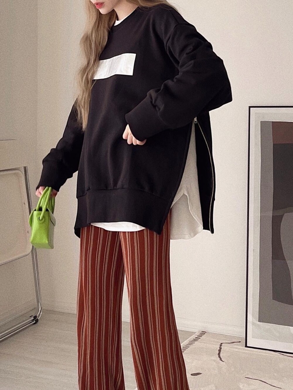 ブラック系のトップス、ホワイト系のTシャツ/カットソー、オレンジ系のその他パンツを着用したレディースの冬コーディネートの3枚目の写真