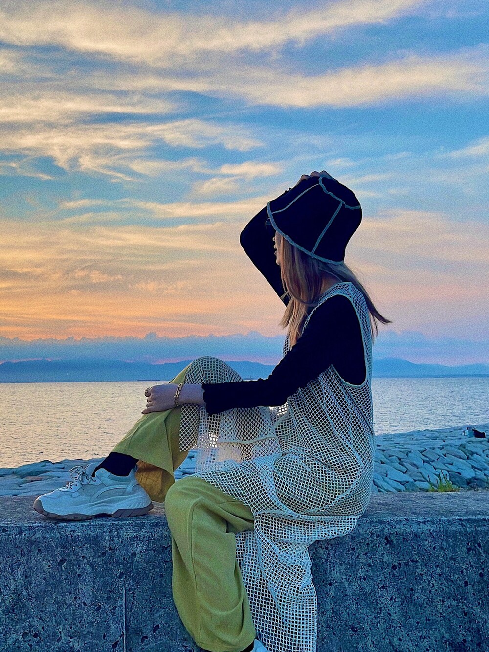 ホワイト系のワンピース、グリーン系のパンツ、ブラック系のトップスを着用したレディースの秋コーディネートの5枚目の写真