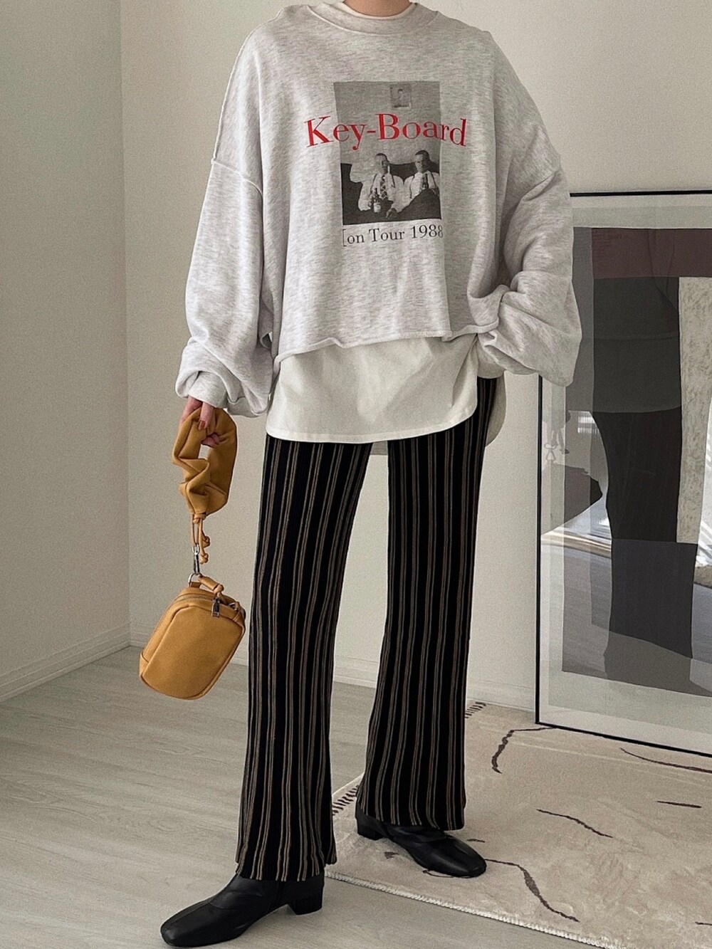 ブラック系のその他パンツ、ベージュ系のショルダーバッグ、ブラック系のブーツを着用したレディースの冬コーディネートの3枚目の写真