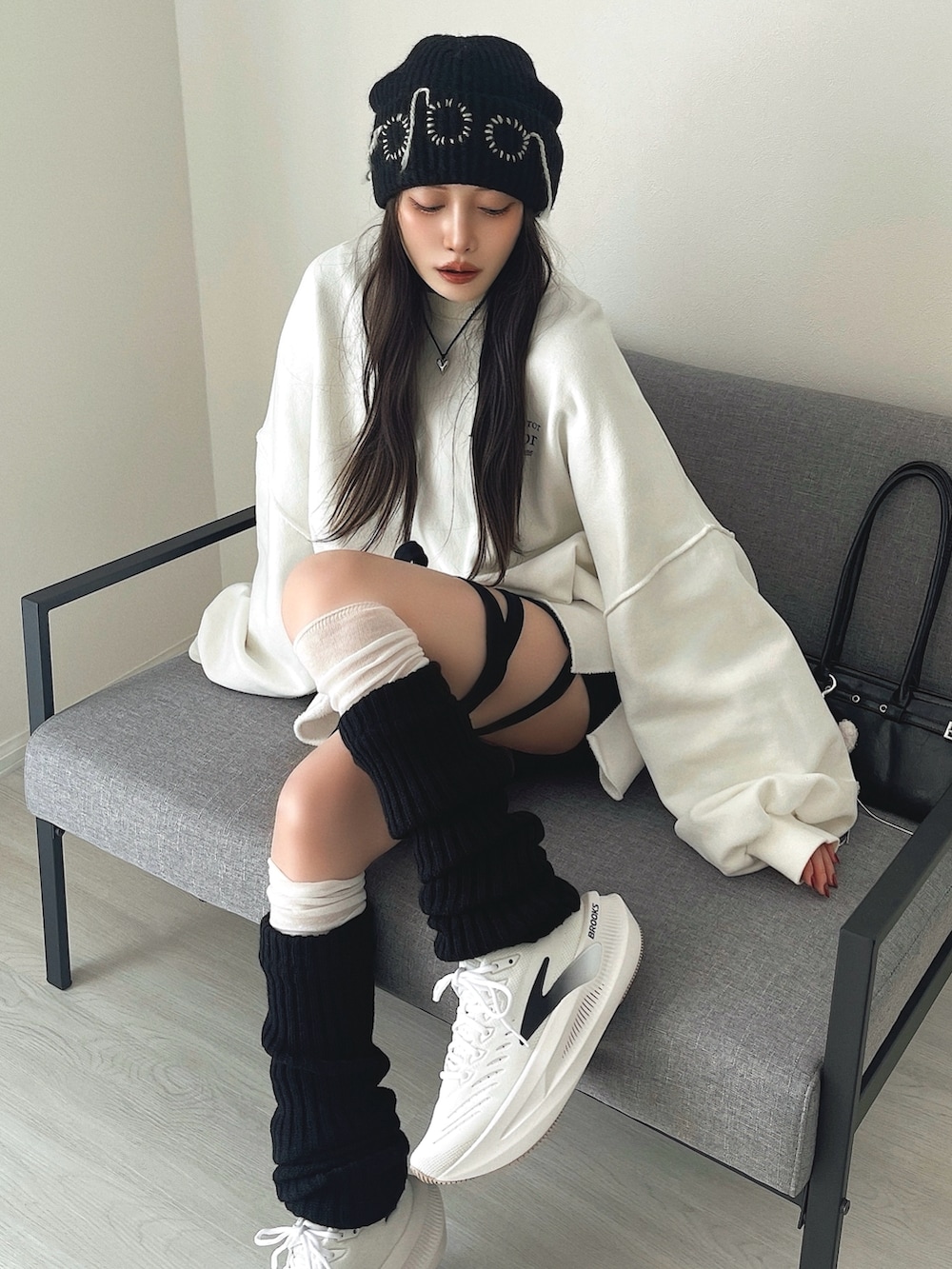 ブラック系のその他パンツ、ブラック系のショルダーバッグ、ホワイト系のシューズを着用したレディースの冬コーディネートの3枚目の写真