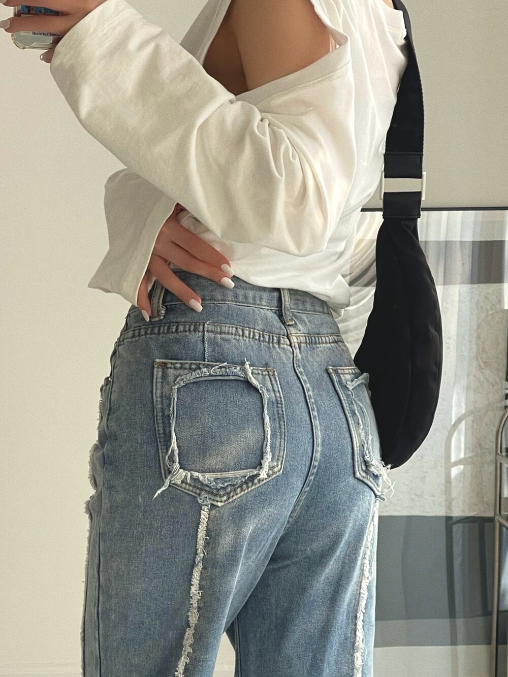 ブルー系のデニムパンツ、ホワイト系のローファー、ホワイト系のTシャツ/カットソーを着用したレディースの冬コーディネートの5枚目の写真