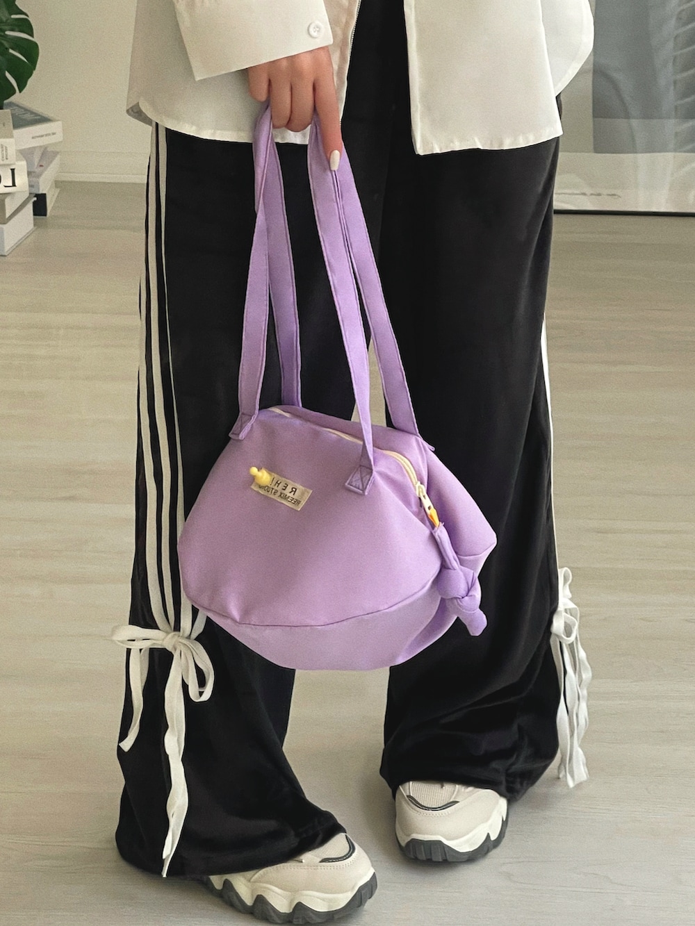 パープル系のショルダーバッグ、ホワイト系のシャツ/ブラウス、ブラック系のその他パンツを着用したレディースの冬コーディネートの4枚目の写真