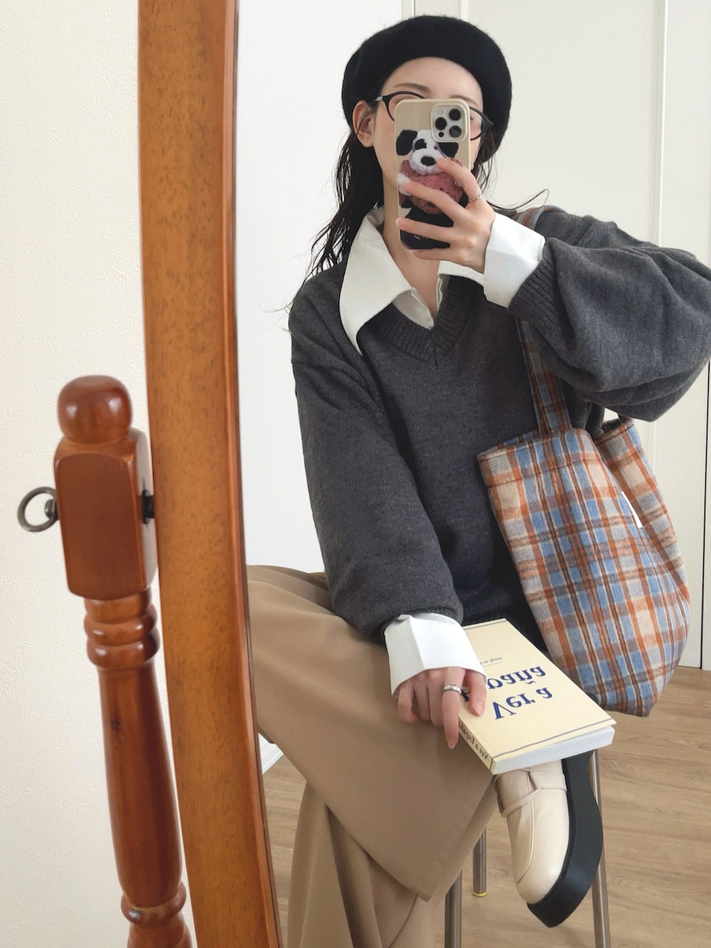 グレー系のニット/セーター、ホワイト系のシャツ/ブラウス、ベージュ系のパンツを着用したレディースの秋コーディネートの3枚目の写真