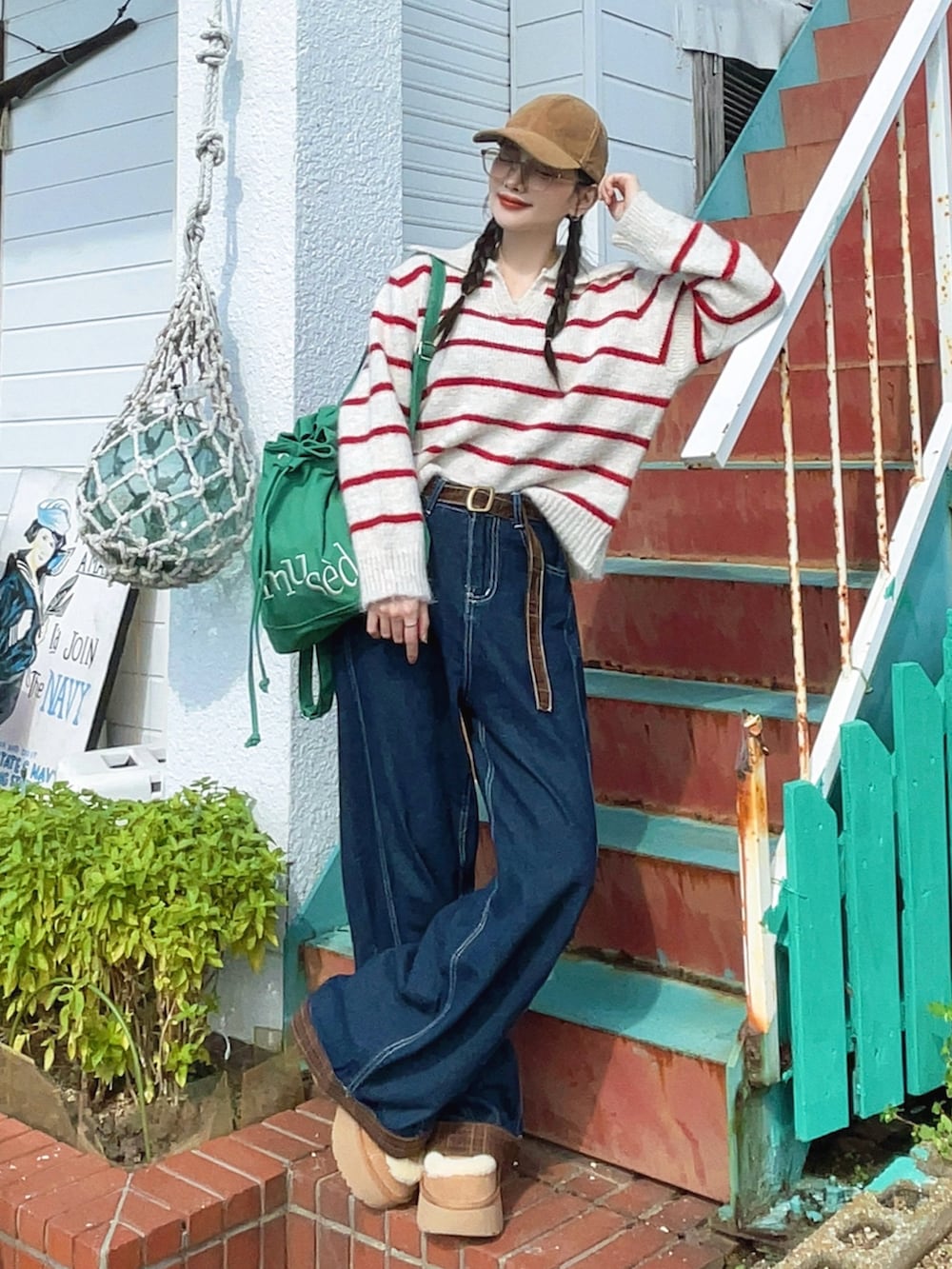 ブルー系のデニムパンツ、グリーン系のバックパック/リュック、ベージュ系のブーツを着用したレディースの秋コーディネートの5枚目の写真