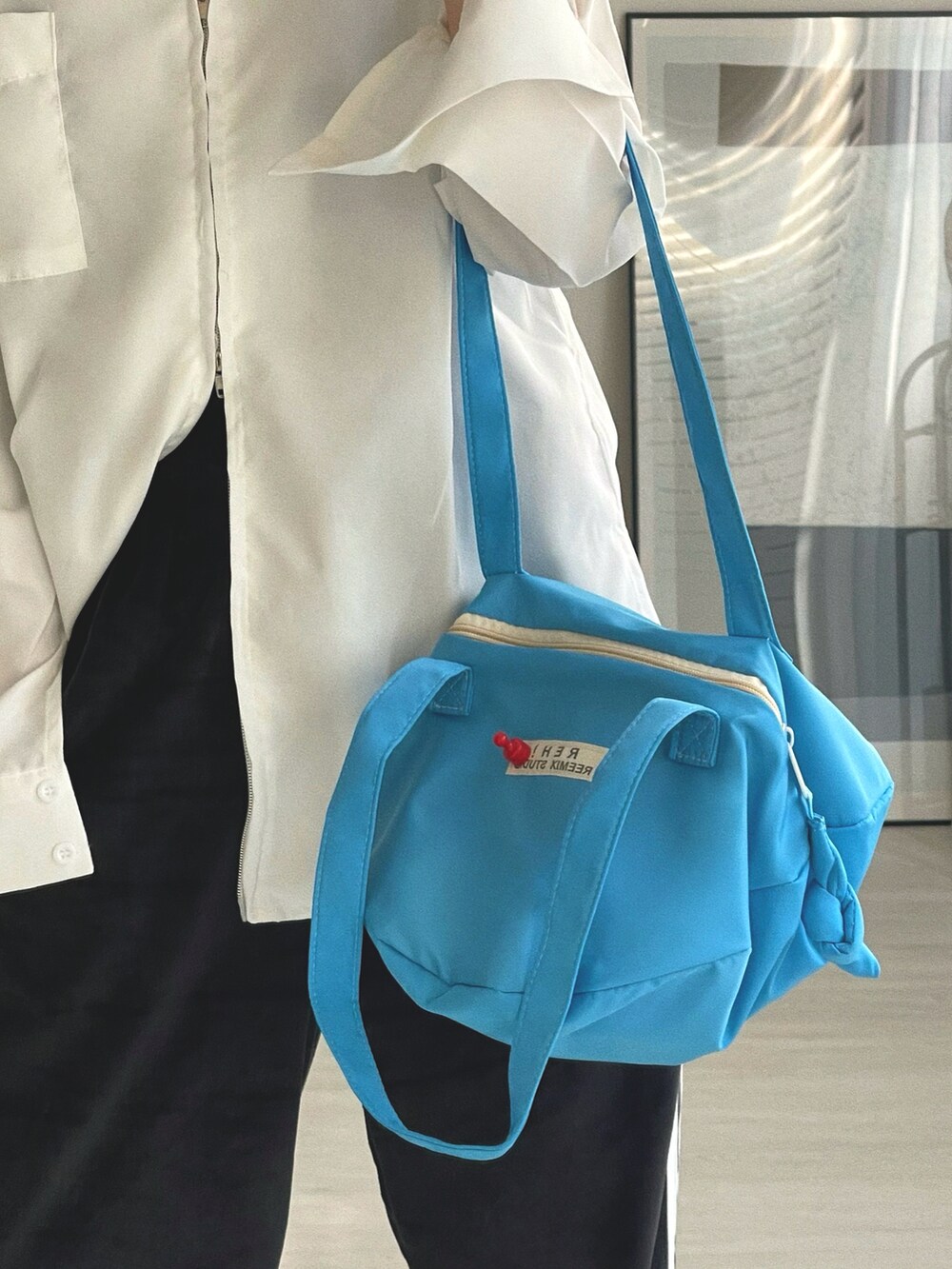 ブルー系のショルダーバッグ、ブラック系のその他パンツ、ホワイト系のシャツ/ブラウスを着用したレディースの冬コーディネートの5枚目の写真