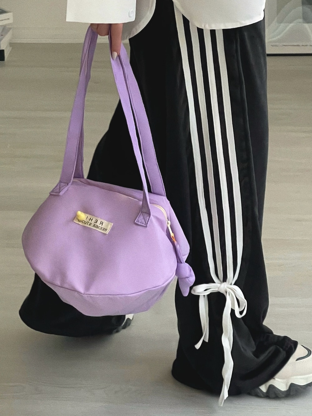 パープル系のショルダーバッグ、ホワイト系のシャツ/ブラウス、ブラック系のその他パンツを着用したレディースの冬コーディネートの5枚目の写真