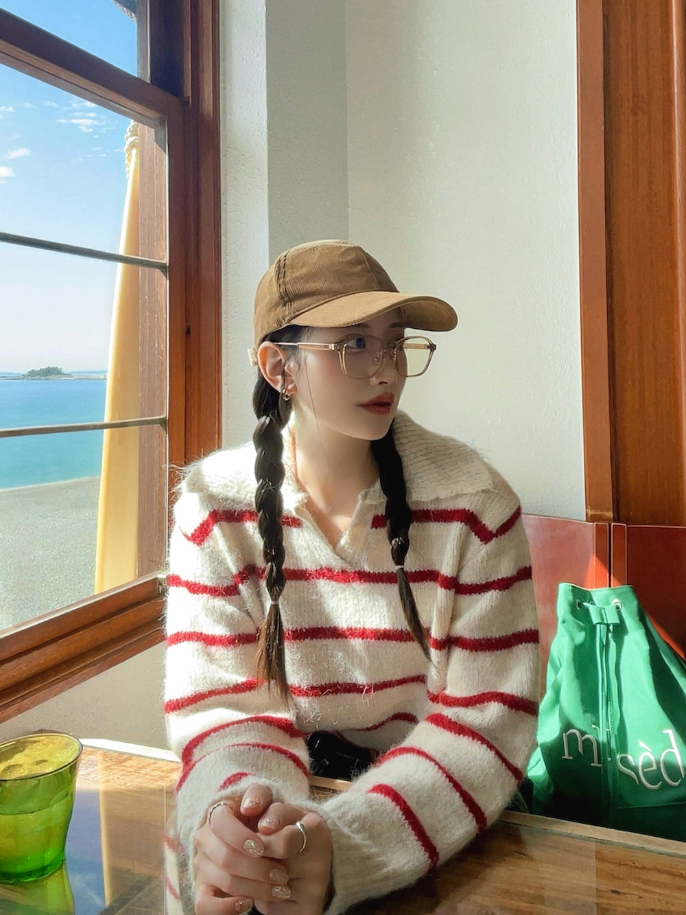 ブルー系のデニムパンツ、グリーン系のバックパック/リュック、ベージュ系のブーツを着用したレディースの秋コーディネートの2枚目の写真