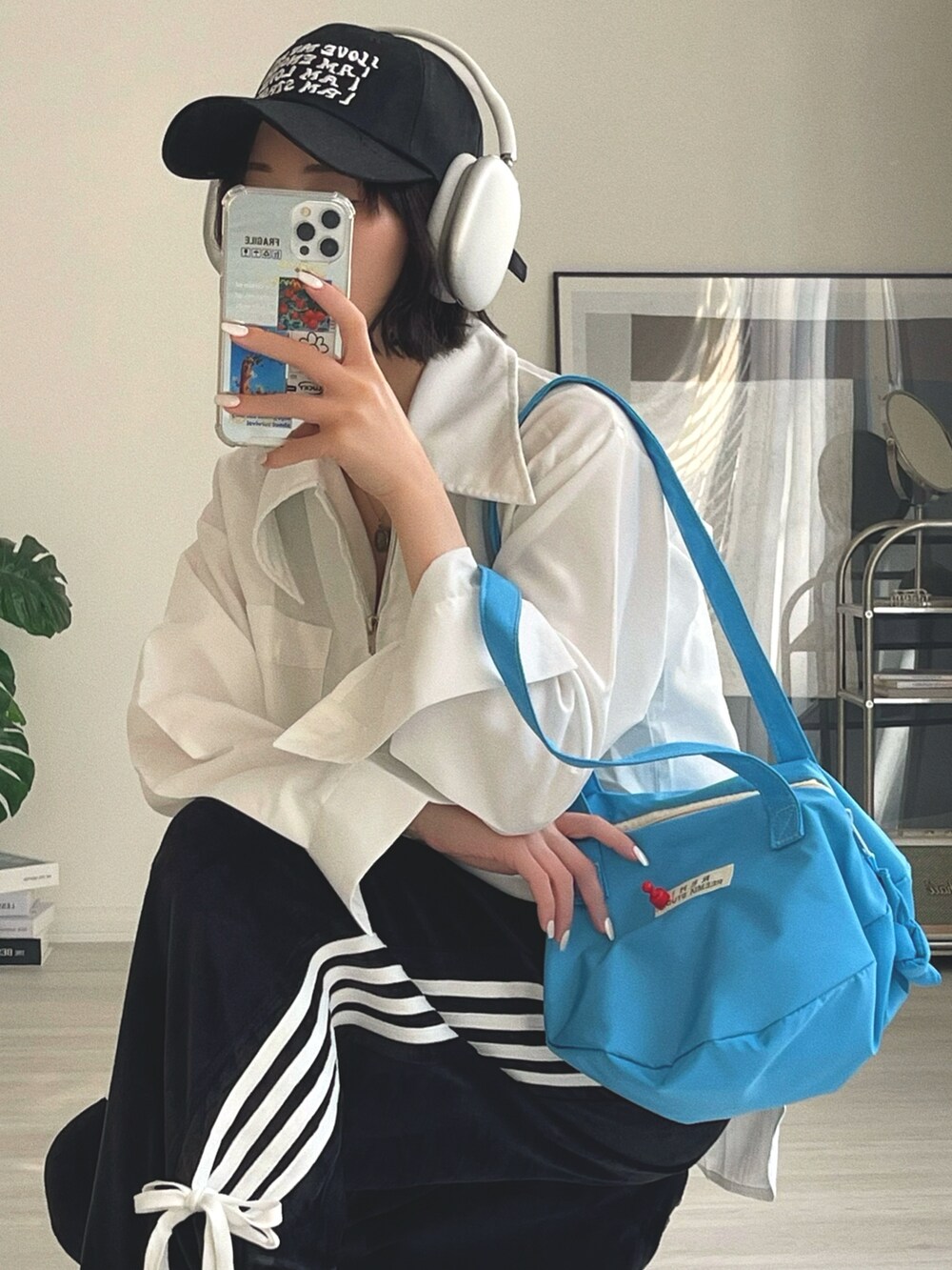 ブルー系のショルダーバッグ、ブラック系のその他パンツ、ホワイト系のシャツ/ブラウスを着用したレディースの冬コーディネートの2枚目の写真