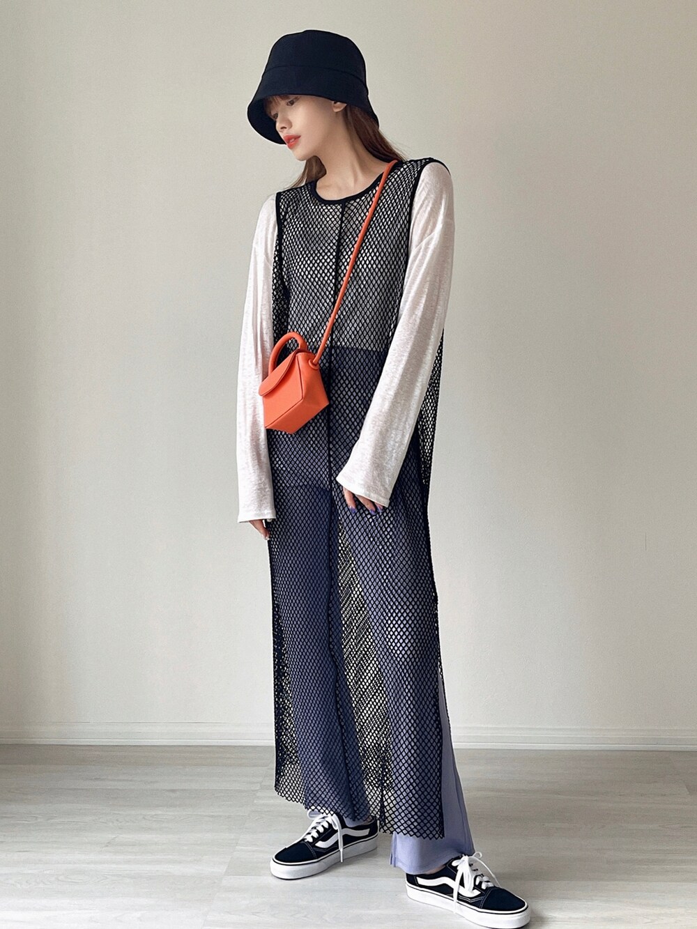 ブラック系のワンピース、オレンジ系のショルダーバッグ、ブラック系のサンダルを着用したレディースの夏コーディネートの5枚目の写真