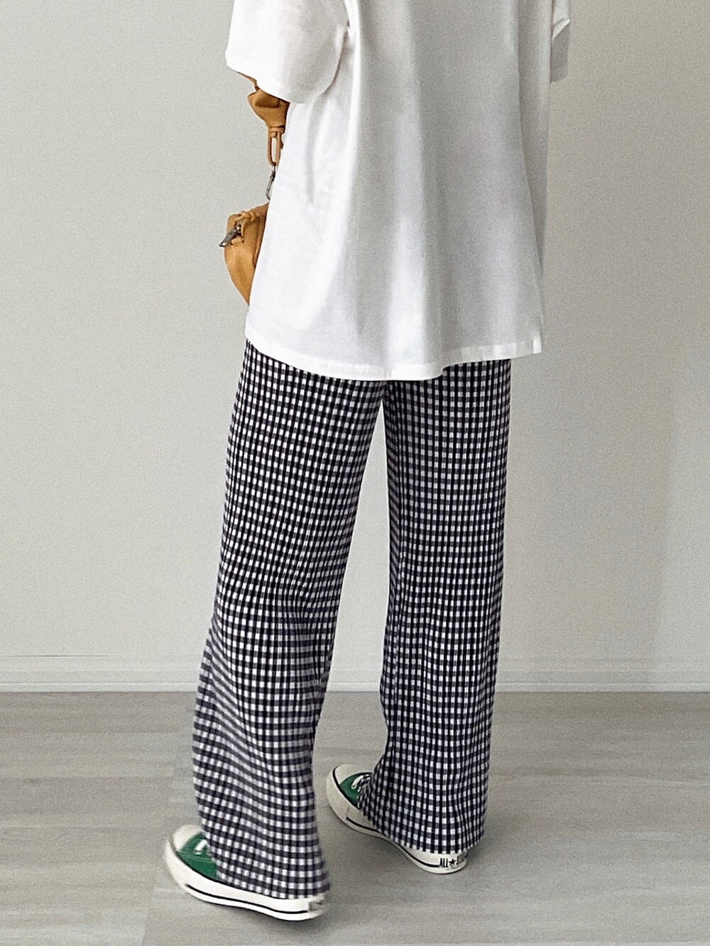 ブラック系のその他パンツ、ベージュ系のショルダーバッグ、グリーン系のスニーカーを着用したレディースの夏コーディネートの2枚目の写真