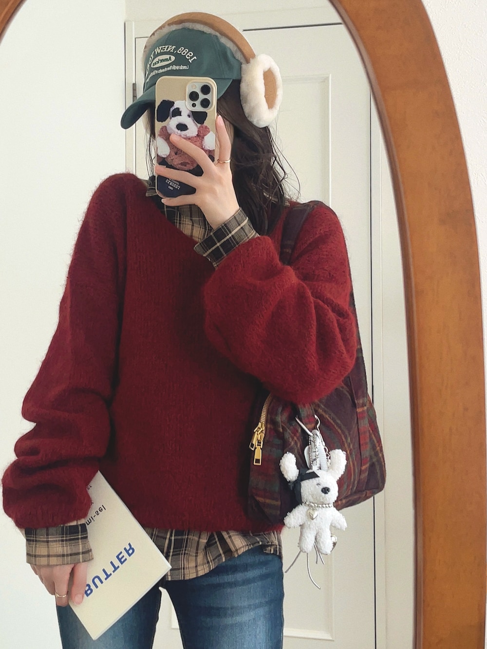 レッド系のニット/セーター、ベージュ系のシャツ/ブラウス、ブラウン系のショルダーバッグを着用したレディースの秋コーディネートの4枚目の写真