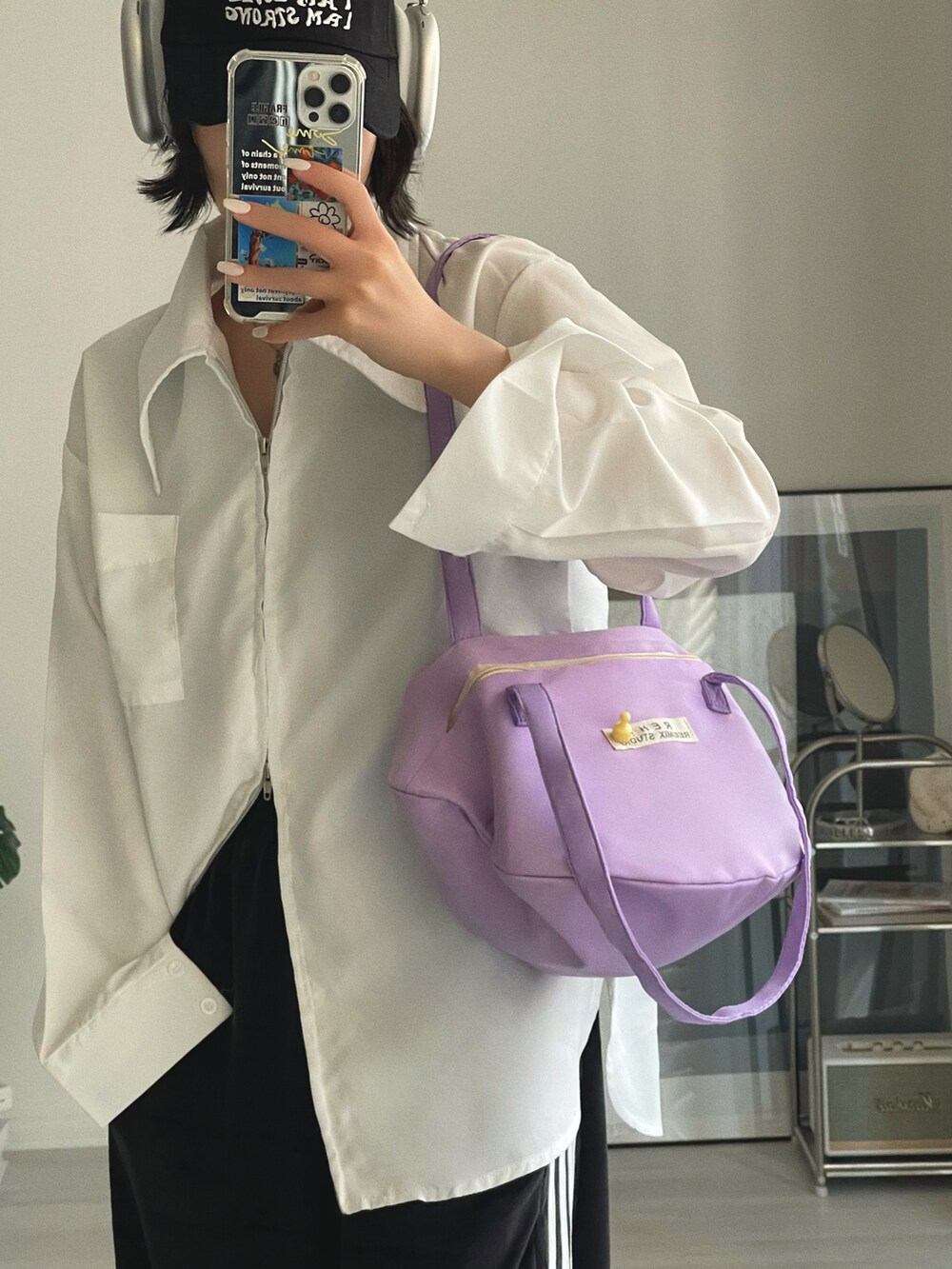 パープル系のショルダーバッグ、ホワイト系のシャツ/ブラウス、ブラック系のその他パンツを着用したレディースの冬コーディネートの2枚目の写真