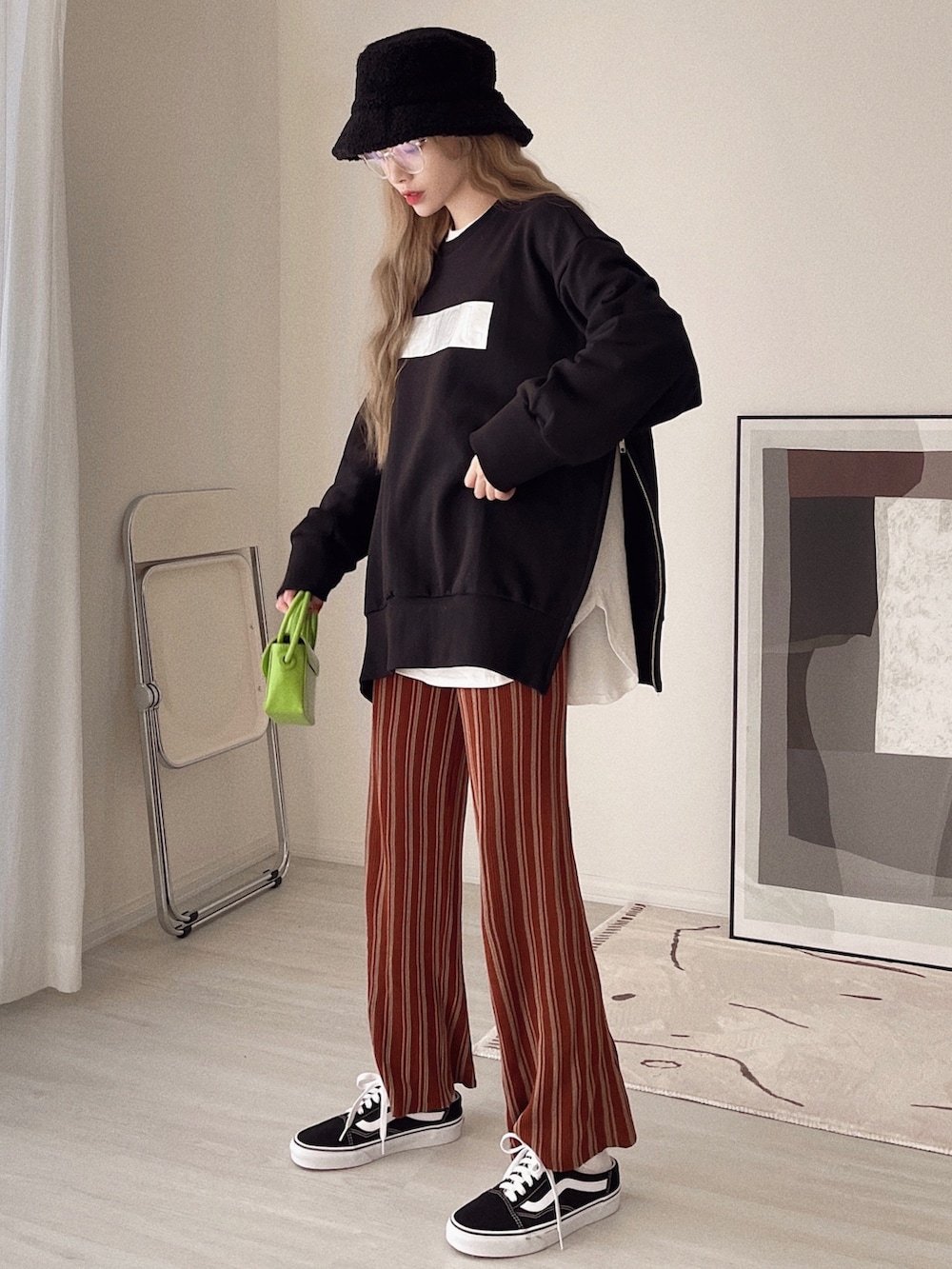 ブラック系のトップス、ホワイト系のTシャツ/カットソー、オレンジ系のその他パンツを着用したレディースの冬コーディネートの2枚目の写真