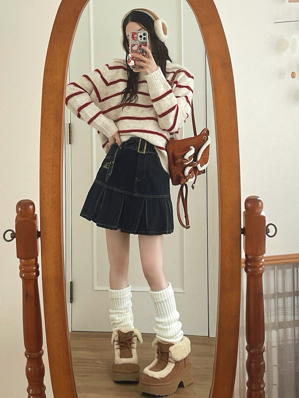 ブラック系のデニムスカート、ベージュ系のブーツ、レッド系のニット/セーターを着用したレディースの秋コーディネートの3枚目の写真