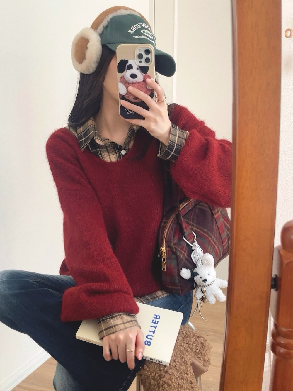 レッド系のニット/セーター、ベージュ系のシャツ/ブラウス、ブラウン系のショルダーバッグを着用したレディースの秋コーディネートの2枚目の写真