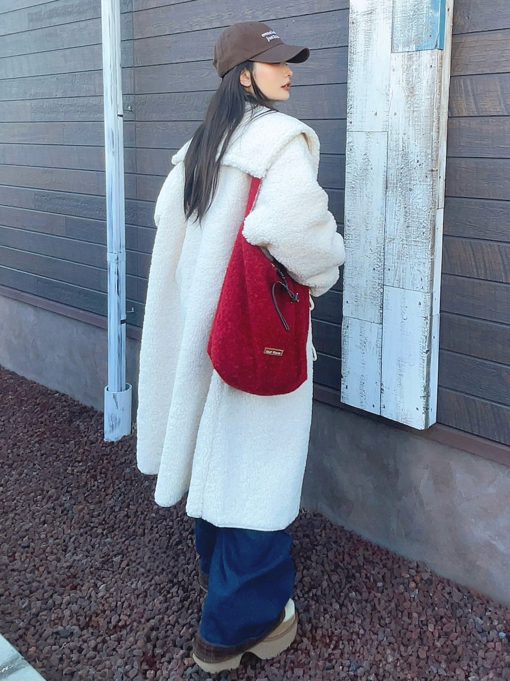 ベージュ系のシャツ/ブラウス、ブルー系のデニムパンツ、レッド系のショルダーバッグを着用したレディースの冬コーディネートの3枚目の写真