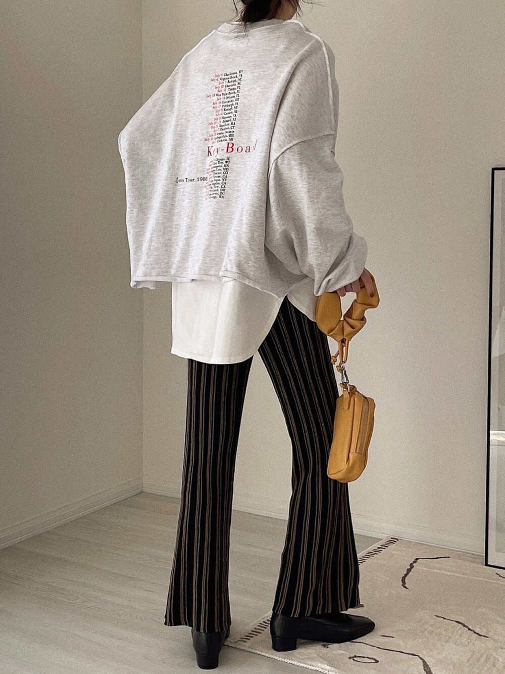 ブラック系のその他パンツ、ベージュ系のショルダーバッグ、ブラック系のブーツを着用したレディースの冬コーディネートの4枚目の写真