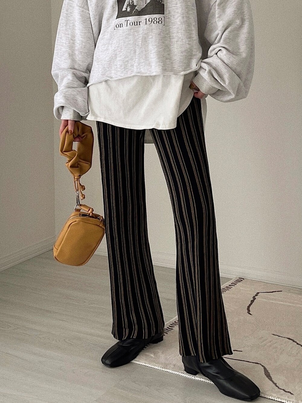 ブラック系のその他パンツ、ベージュ系のショルダーバッグ、ブラック系のブーツを着用したレディースの冬コーディネートの5枚目の写真