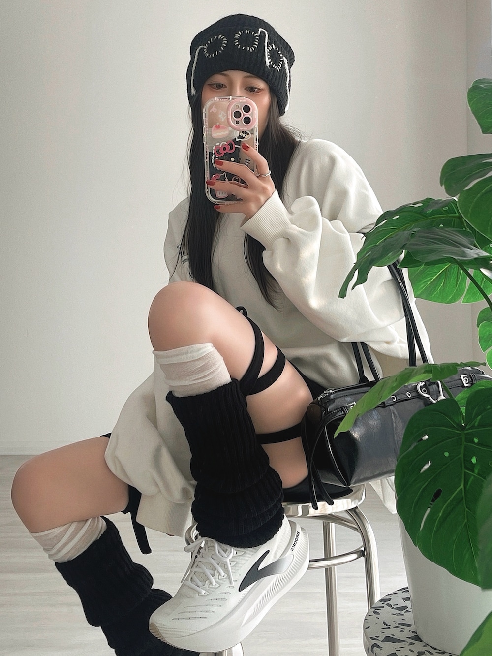 ブラック系のその他パンツ、ブラック系のショルダーバッグ、ホワイト系のシューズを着用したレディースの冬コーディネートの2枚目の写真