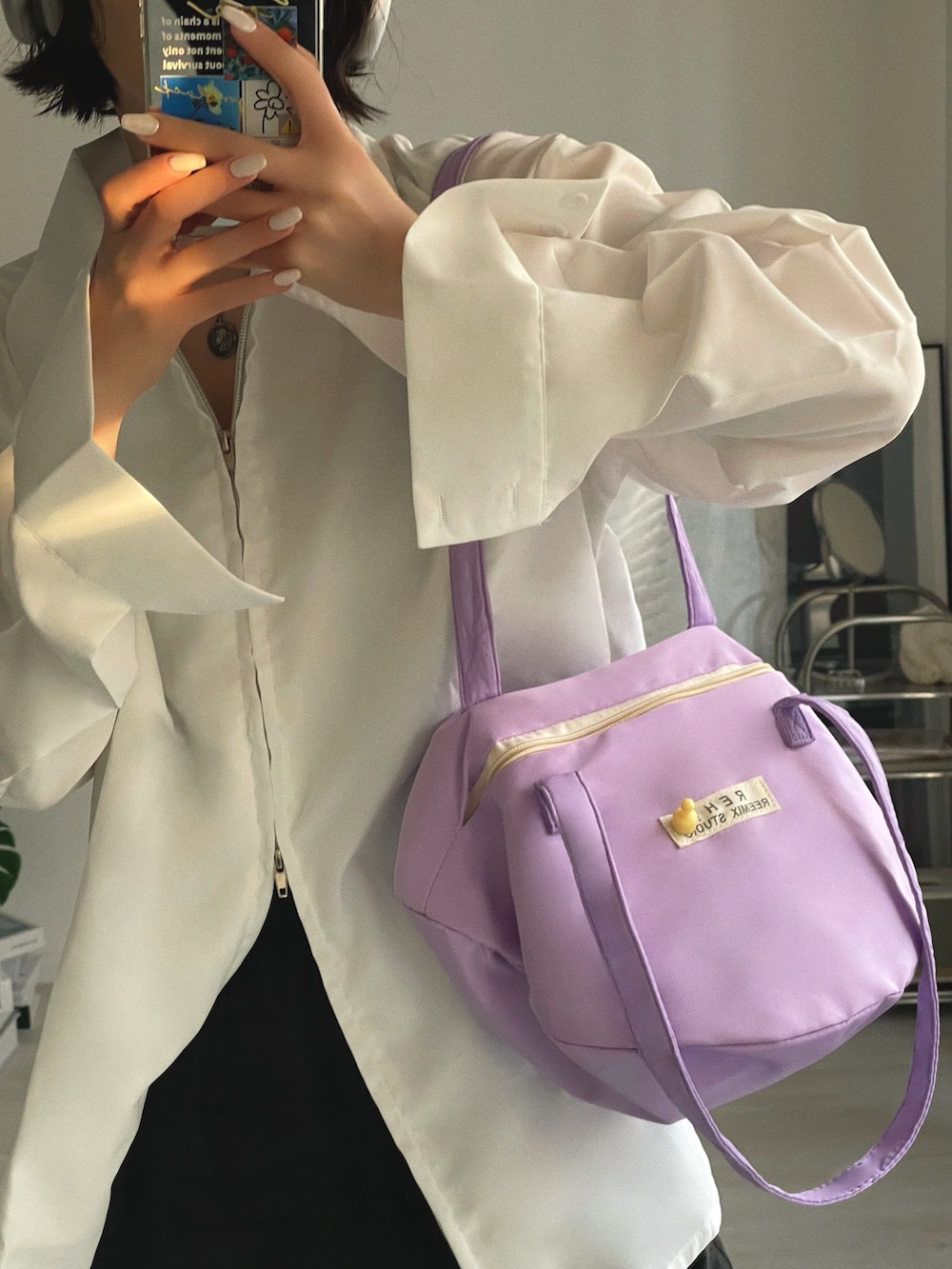 パープル系のショルダーバッグ、ホワイト系のシャツ/ブラウス、ブラック系のその他パンツを着用したレディースの冬コーディネートの3枚目の写真