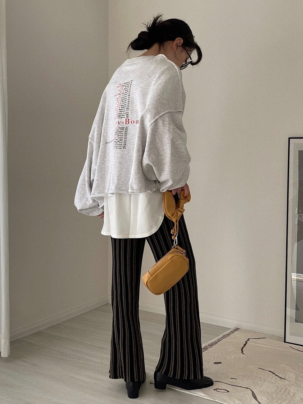 ブラック系のその他パンツ、ベージュ系のショルダーバッグ、ブラック系のブーツを着用したレディースの冬コーディネートの2枚目の写真