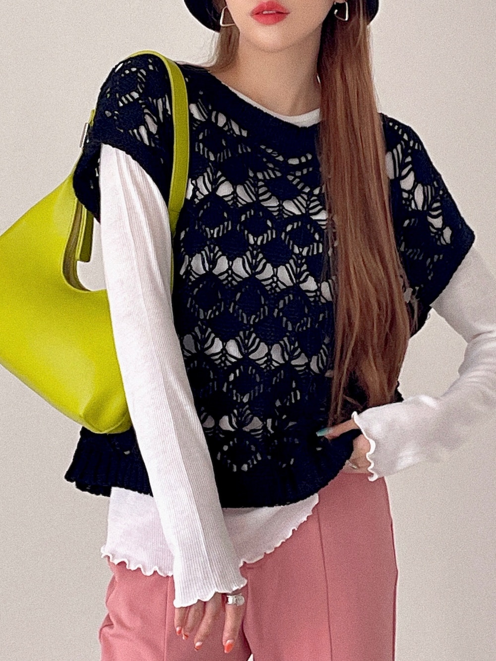 ブラック系のベスト、ホワイト系のトップス、ピンク系のパンツを着用したレディースの夏コーディネートの4枚目の写真