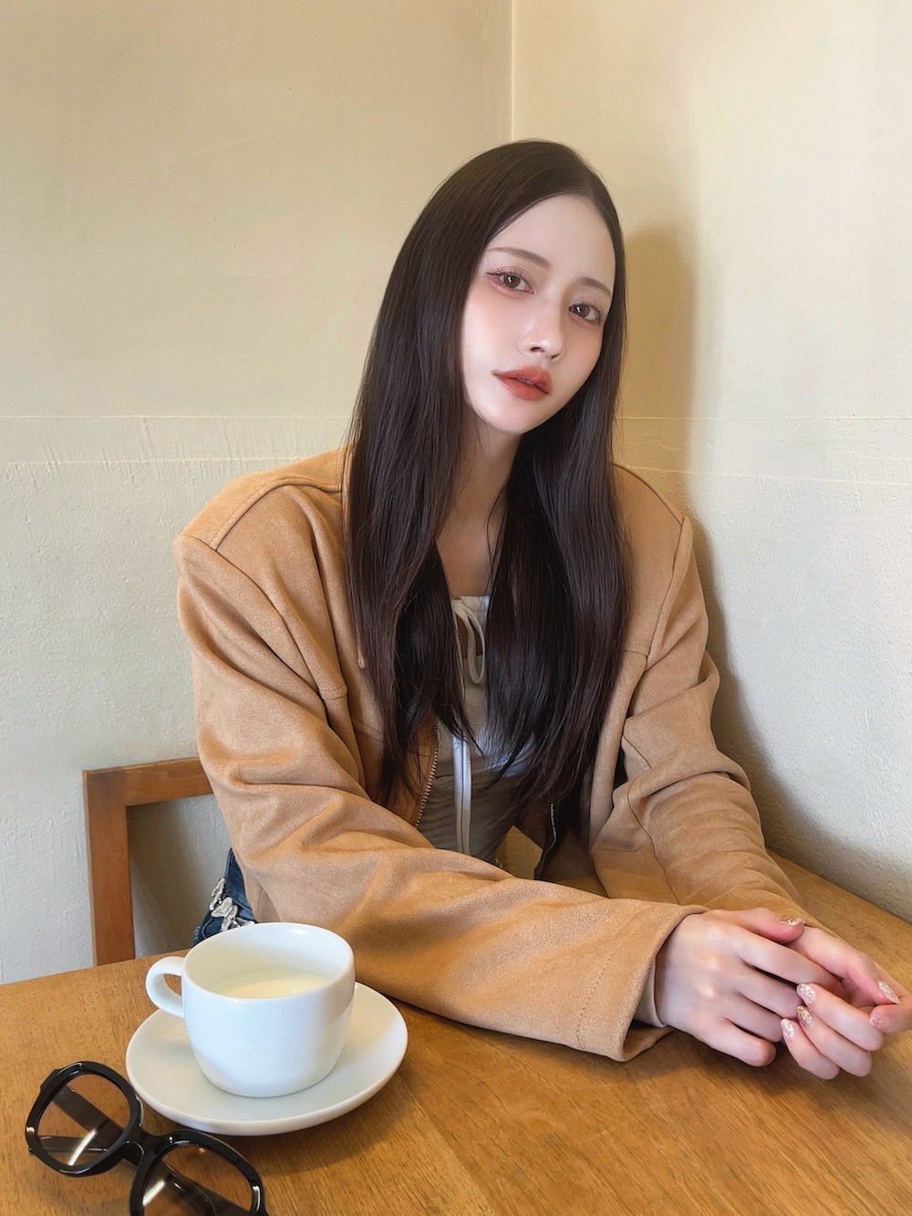 ベージュ系のジャケット/アウター、ホワイト系のトップス、ブルー系のデニムパンツを着用したレディースの秋コーディネートの3枚目の写真