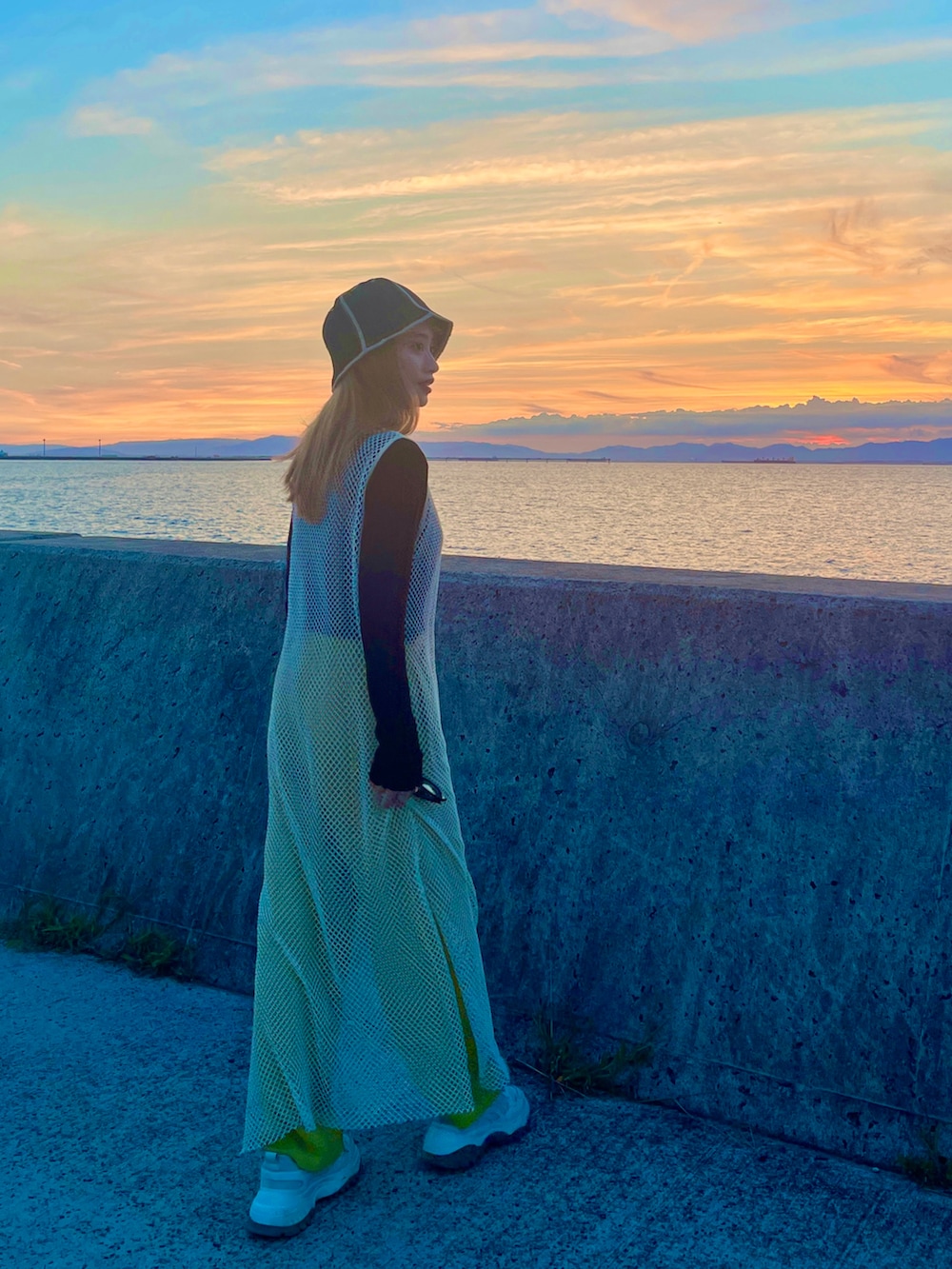 ホワイト系のワンピース、グリーン系のパンツ、ブラック系のトップスを着用したレディースの秋コーディネートの3枚目の写真