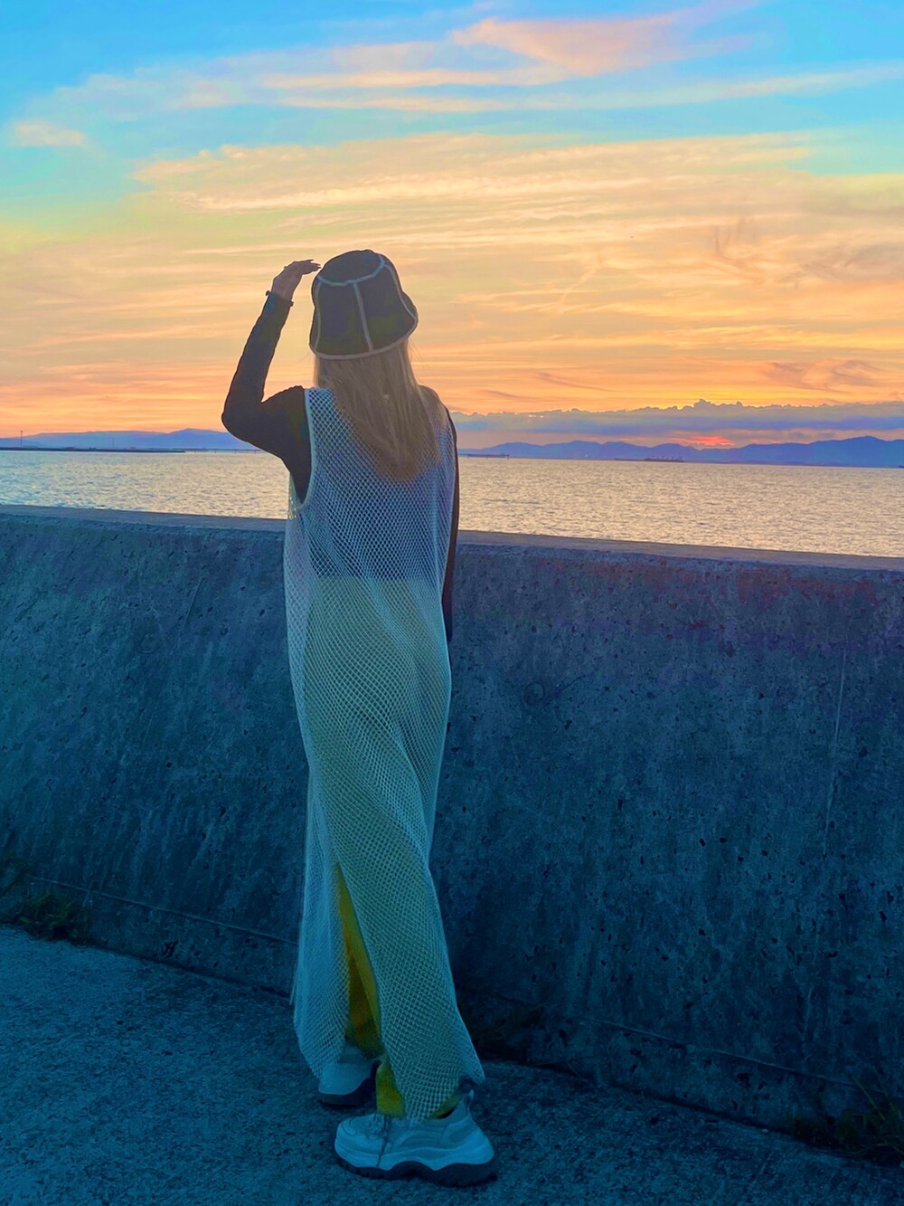 ホワイト系のワンピース、グリーン系のパンツ、ブラック系のトップスを着用したレディースの秋コーディネートの4枚目の写真