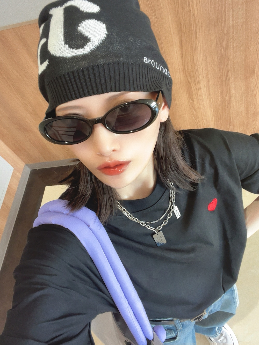 グレー系のトートバッグ、ブラック系のTシャツ/カットソー、ブルー系のデニムパンツを着用したレディースの夏コーディネートの2枚目の写真