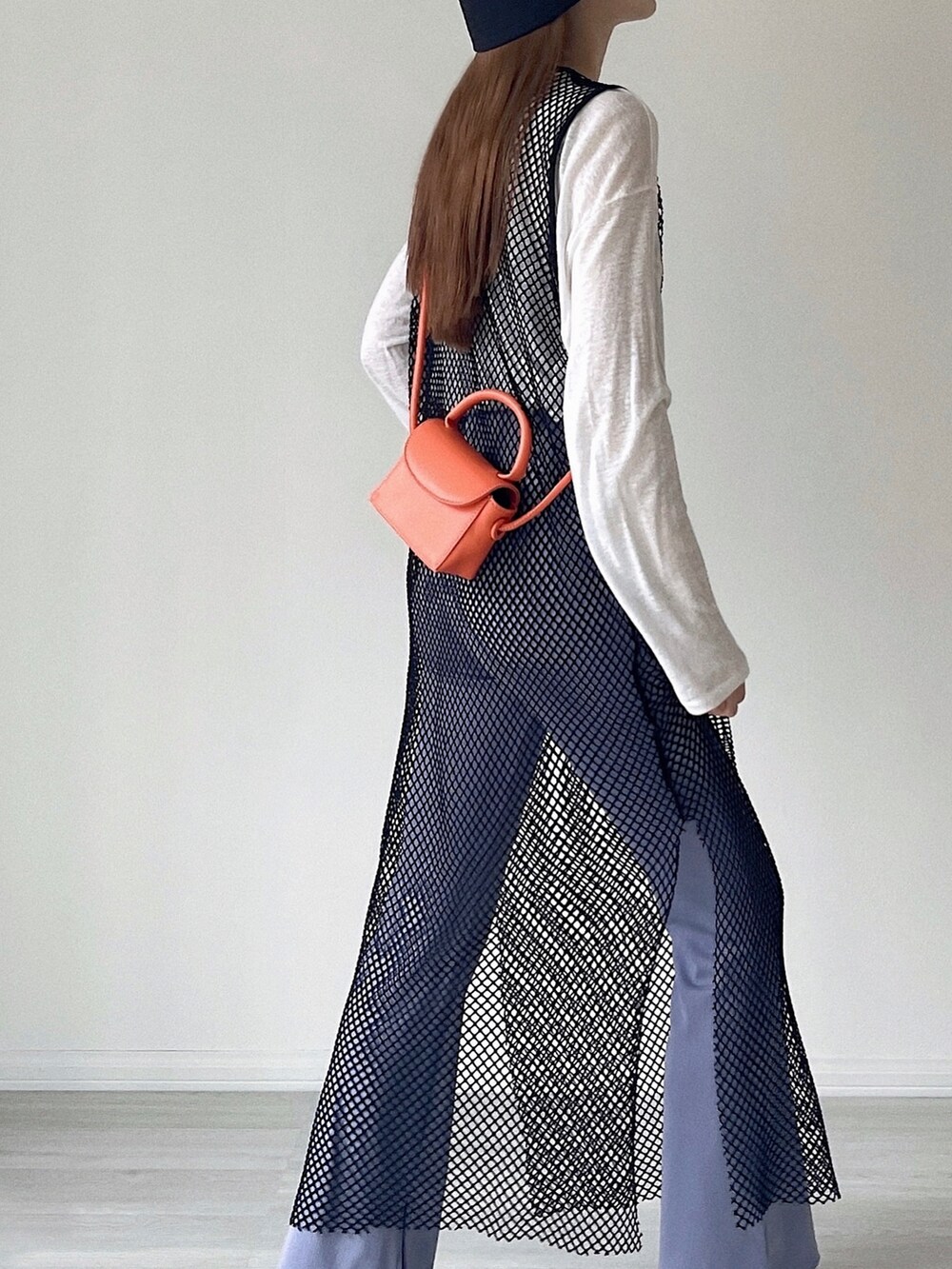 ブラック系のワンピース、オレンジ系のショルダーバッグ、ブラック系のサンダルを着用したレディースの夏コーディネートの3枚目の写真