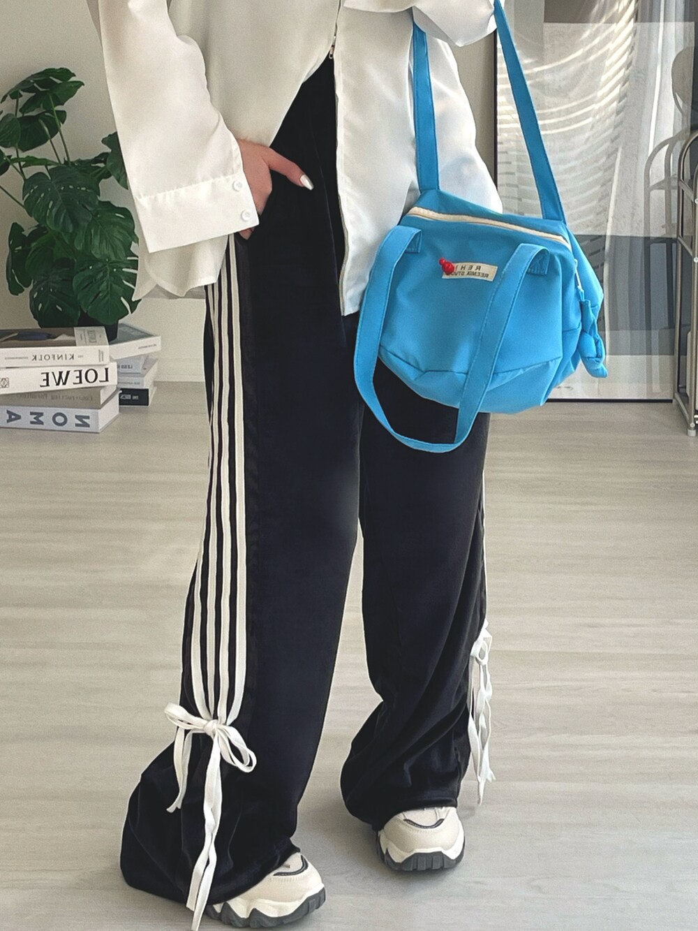 ブルー系のショルダーバッグ、ブラック系のその他パンツ、ホワイト系のシャツ/ブラウスを着用したレディースの冬コーディネートの3枚目の写真