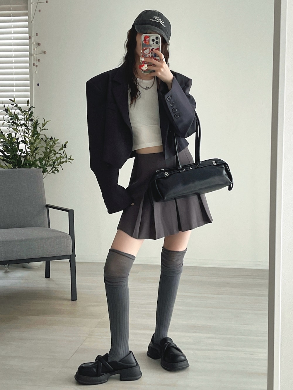 ホワイト系のタンクトップ、ブラック系のローファー、グレー系のジャケット/アウターを着用したレディースの秋コーディネートの5枚目の写真