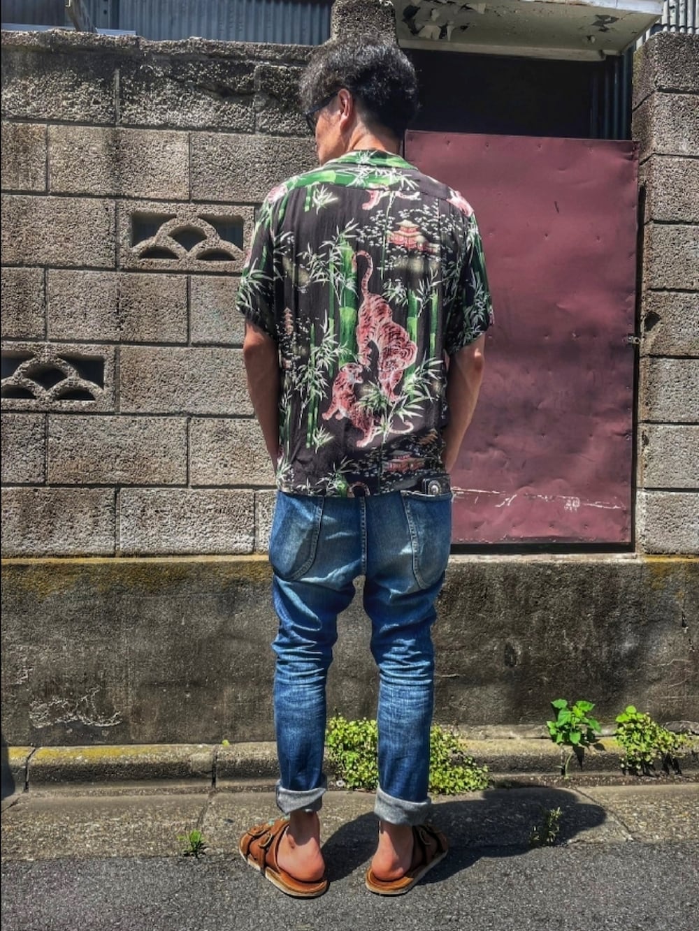 ブラック系のシャツ/ブラウス、ブルー系のデニムパンツ、ブラウン系のサンダルを着用したメンズの秋コーディネートの4枚目の写真