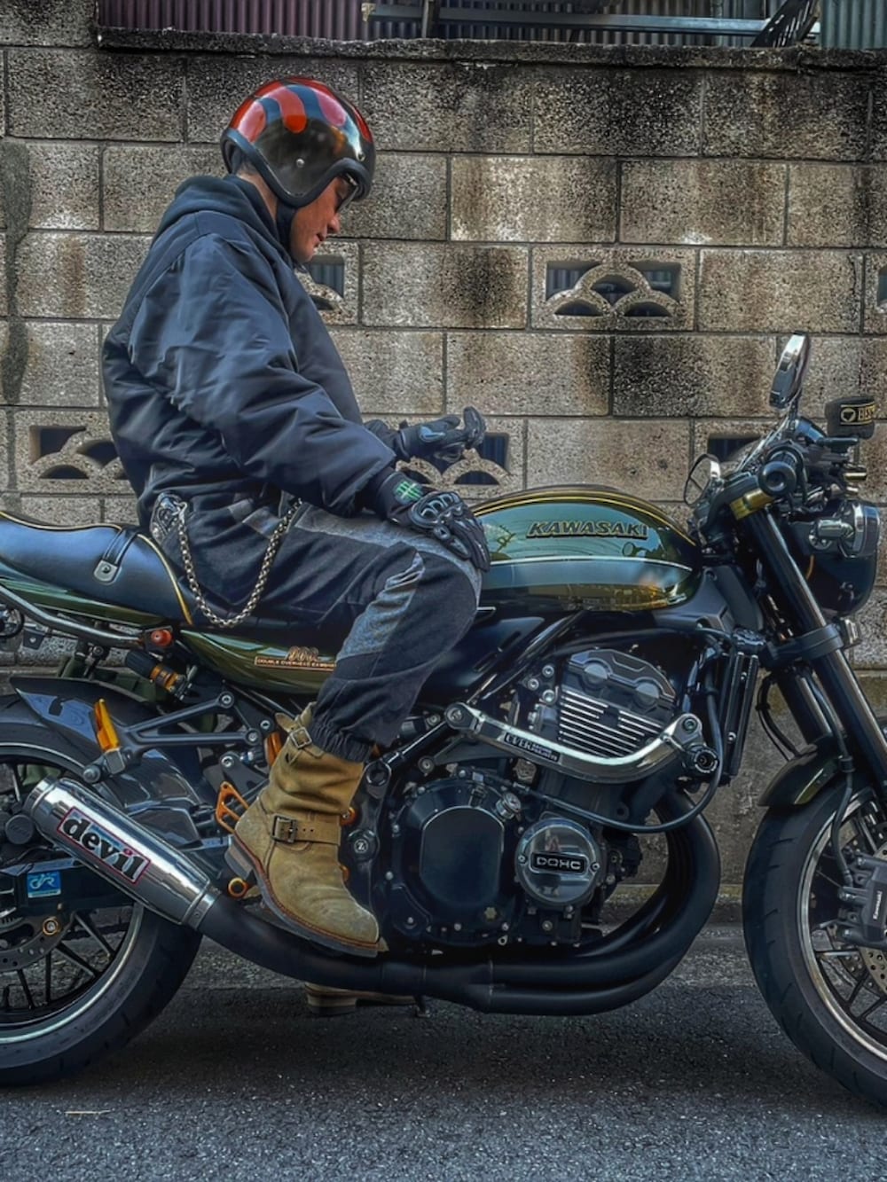 ブラック系のナイロンジャケット、ブラック系のデニムパンツ、ベージュ系のブーツを着用したメンズの秋コーディネートの2枚目の写真